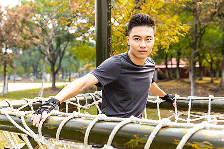 运动男户外攀爬绳梯的男性背景