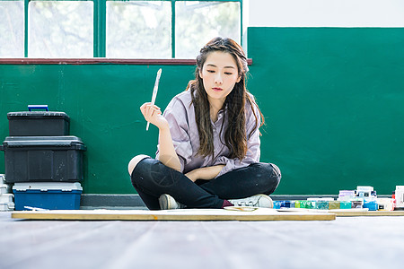 青春女孩坐地上画油画高清图片