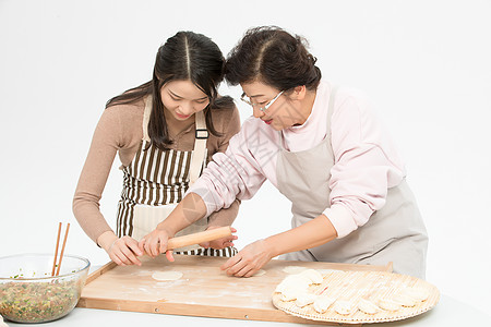 女儿和妈妈一起包饺子背景图片