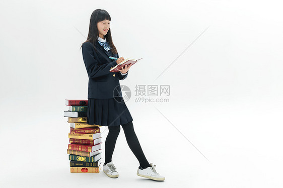 女学生靠着书本写作业图片