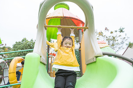 黄色滑滑梯幼儿园女孩玩滑滑梯背景