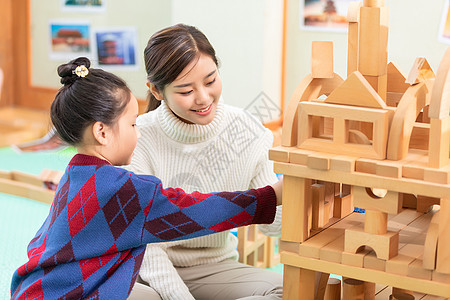 幼儿园老师陪学生玩积木高清图片