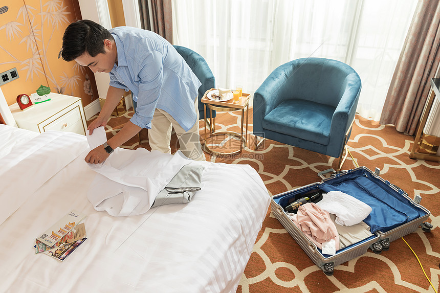 酒店客房整理行李的男人图片
