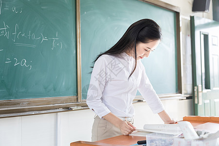 学校讲台女教师认真上课背景