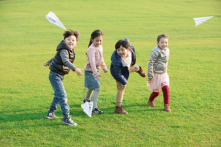 快乐放假草地上玩纸飞机的孩子们背景