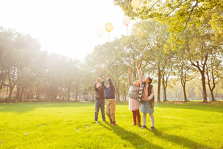 阳光下快乐儿童们拿气球高清图片