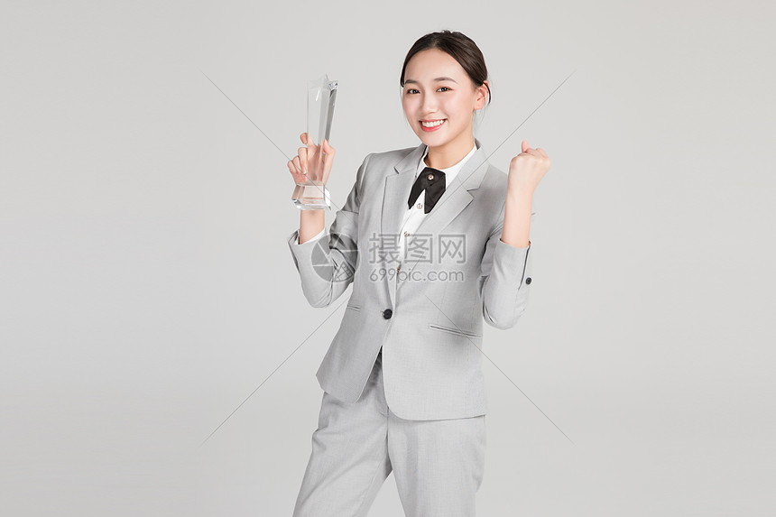 商务美女手握奖杯图片