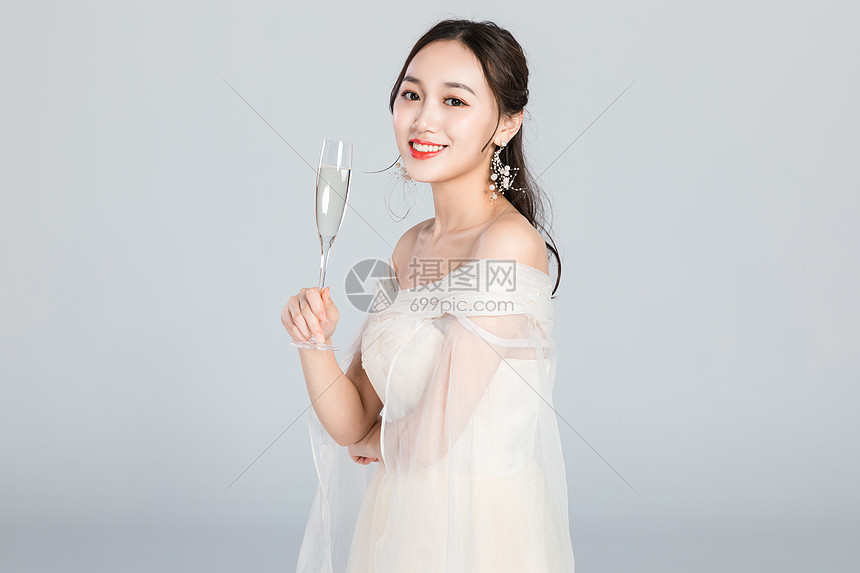 优雅的女人手拿香槟酒杯图片