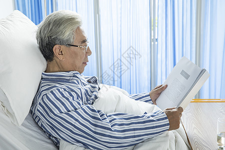 老年病人病床看书背景图片