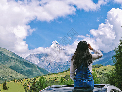 维族姑娘眺望四姑娘雪山的少女背影背景