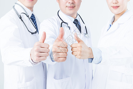 年轻的医生们举大拇指特写图片