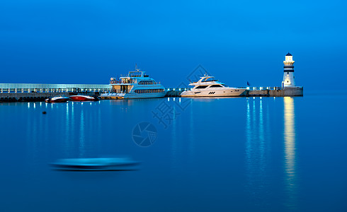 海边灯塔宁静的海面码头风光背景