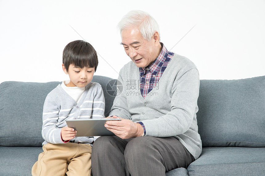 祖孙在沙发上使用平板电脑图片