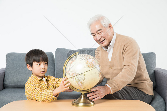 祖孙在沙发上看地球仪图片