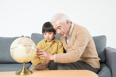 祖孙在沙发上看地球仪高清图片