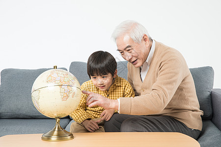 祖孙在沙发上看地球仪背景图片