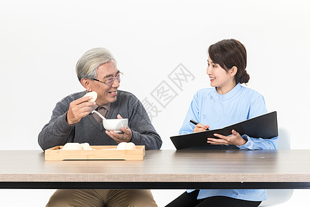 女吃饭女护理人员与老人交谈背景