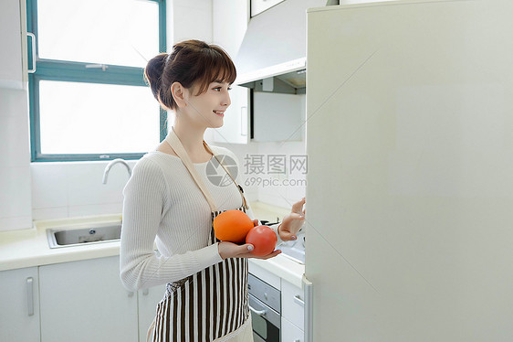 从冰箱里拿蔬果的家庭主妇图片