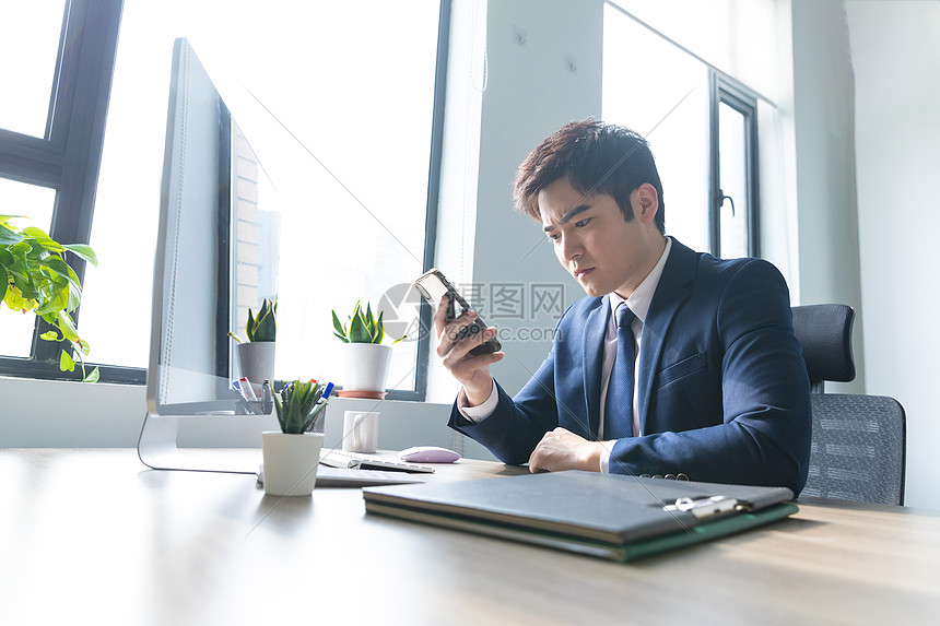 商务男士办公室查看手机图片