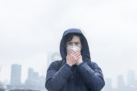 防毒面具口罩在雾霾中捂住口鼻背景