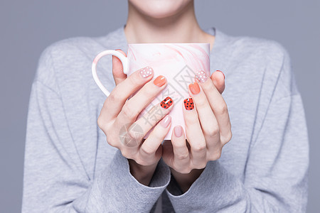 女性美甲手捧水杯特写图片