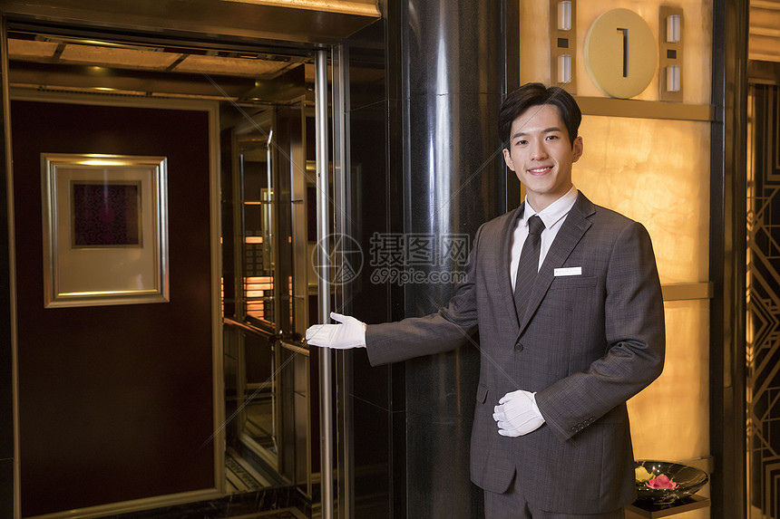 酒店服务员为顾客开电梯