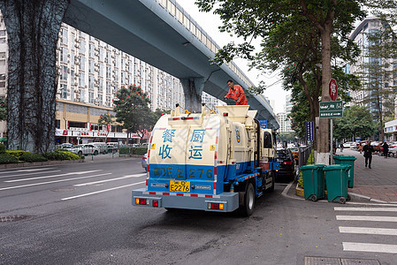 辛勤工作的劳动者 环卫工人站在路边的餐余垃圾收运车背景图片