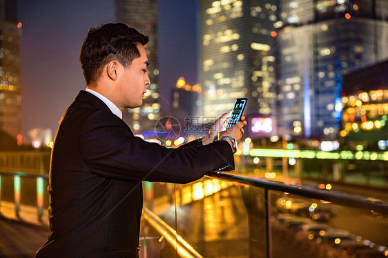 年轻商务男子天桥玩手机图片