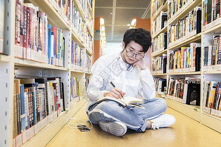 看书的男生在图书馆学习的大学生背景