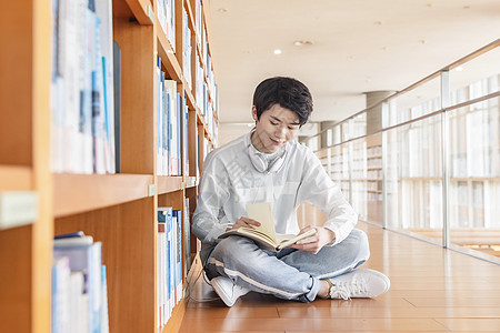 男生睡觉在图书馆看书的学生背景