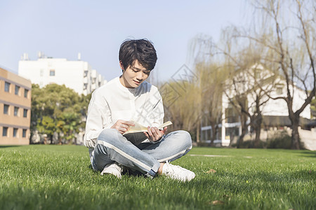 男性在草坪上阅读高清图片