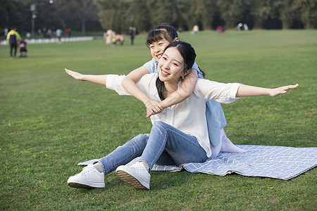 亲子游玩女儿和妈妈草地上玩耍背景