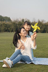 海边亲子妈妈和女儿在草坪玩耍背景