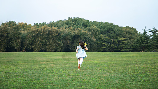 女孩在草地上奔跑图片