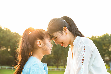 妈妈和女儿在草坪玩耍背景图片