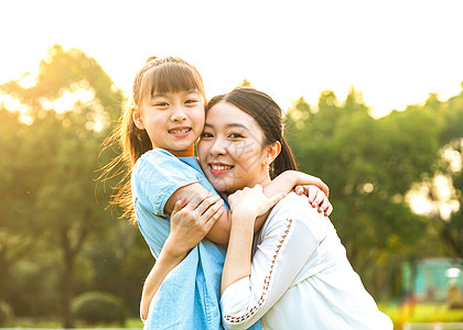 亲子游玩妈妈和女儿在草坪玩耍背景