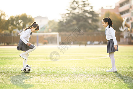 校园操场小女孩踢足球背景
