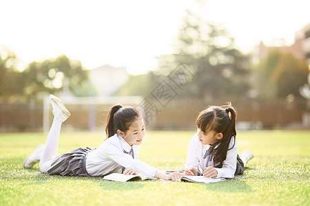 学校儿童节小学生趴在操场学习背景