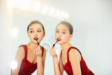 性感美女化妆镜前涂口红背景图片