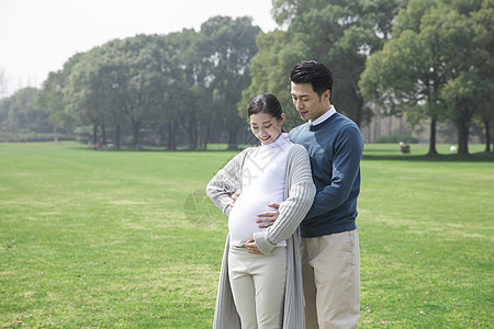 丈夫陪孕妇在公园背景图片