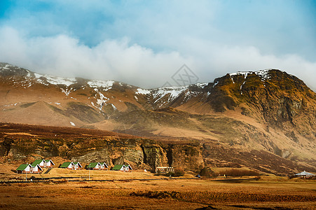 冰岛冰川山脉下的绿色房子高清图片