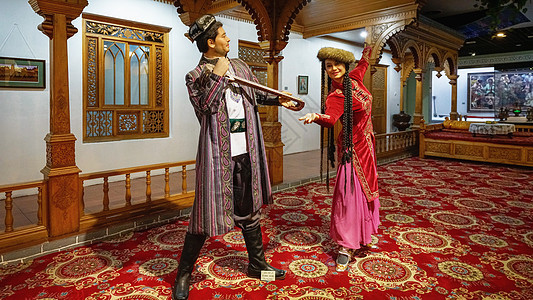 新疆民族风俗雕像背景图片