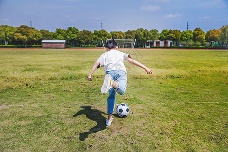 踢足球的小男孩小学生操场踢足球背景