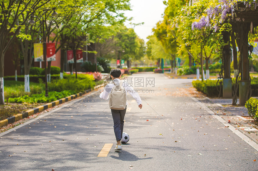 小男孩放学踢足球图片