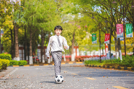  小男孩放学踢足球图片