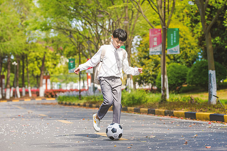 小男孩放学踢足球图片