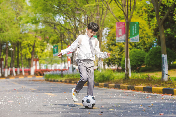 小男孩放学踢足球图片