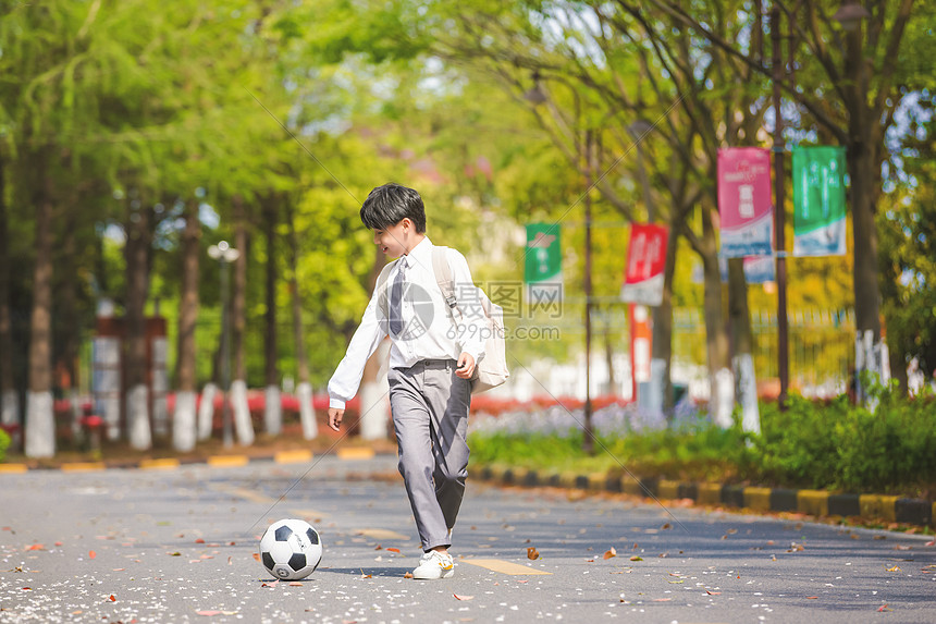 小男孩放学踢足球图片