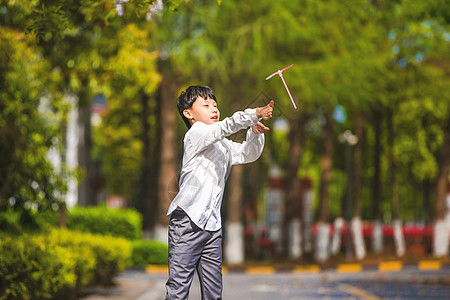 飞起来的小男孩儿童节小学生飞竹蜻蜓背景