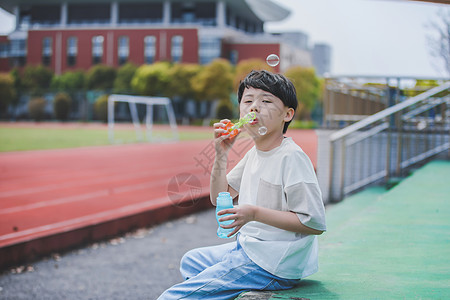 七夕快乐小男孩操场吹泡泡背景